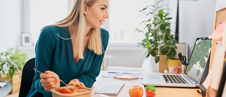 Vrouw eet in kantoor aan huis