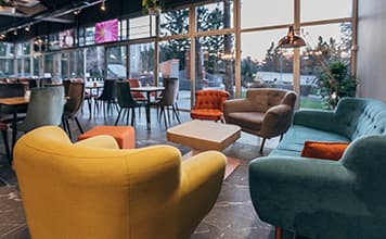 Café-cantine avec fauteuils colorés et grande devanture vitrée