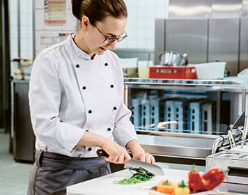 Frontcooking Köchin bei der Vorbereitung, Gemüse schneiden