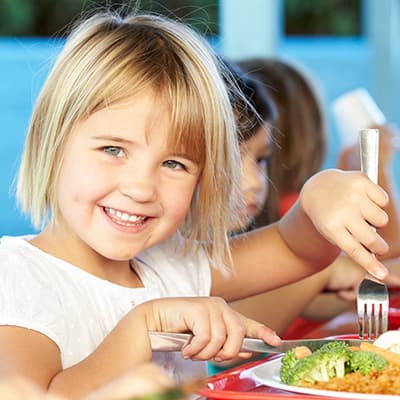 Little girl eating and smiling