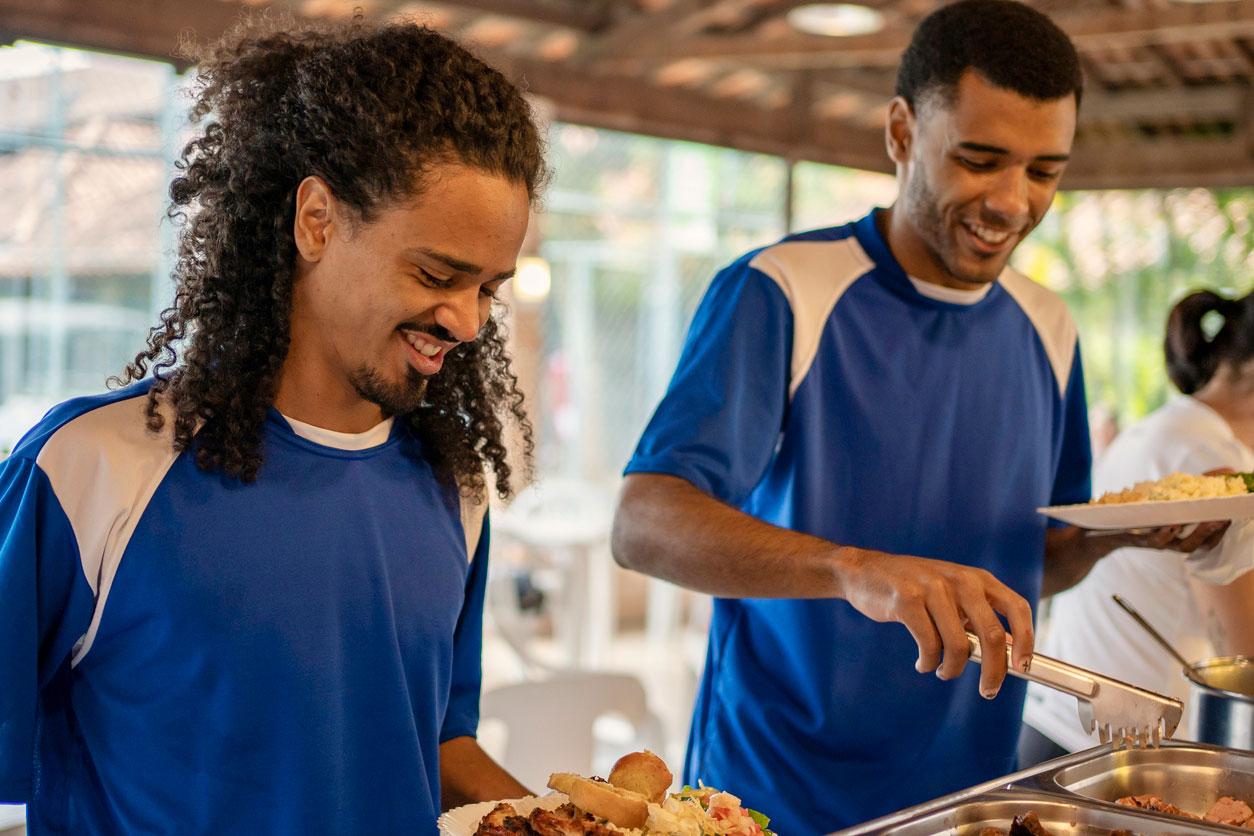 Zwei Männer mit Sportkleidung am Buffet